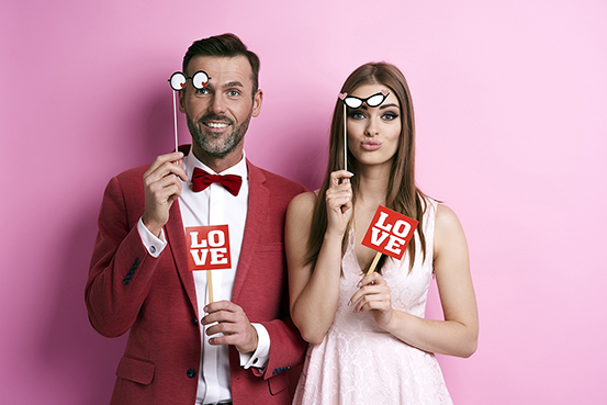 Portrait of couple with photo booth partying